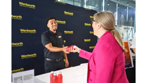 a person hands a sports drink bottle to another person