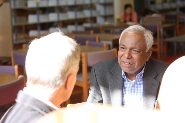 Professor Bhatti talks with colleagues.