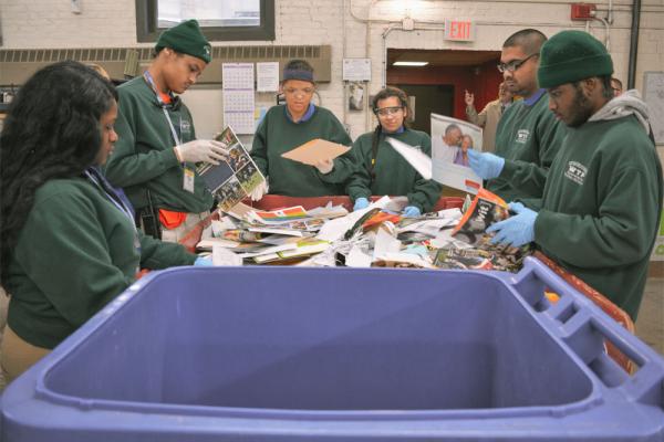 A diverse group of students sorting recycling