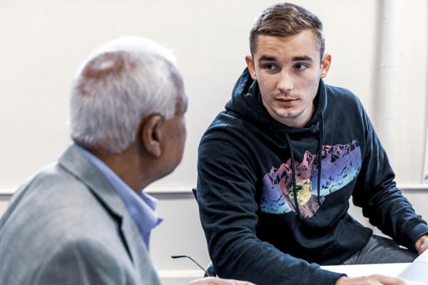 A male student talks to a professor
