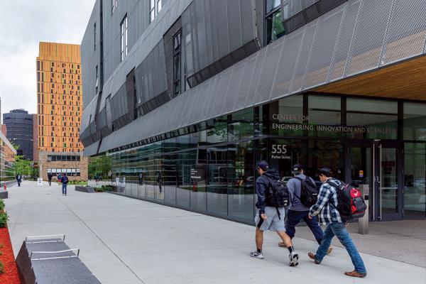 Three students walk past the CEIS building. 