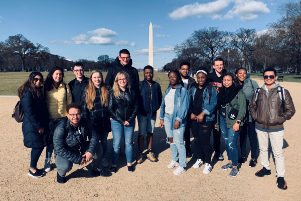 students standing outside in front of a monument