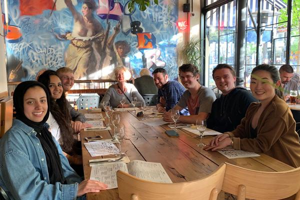 Group of students and faculty on study abroad trip sitting at table