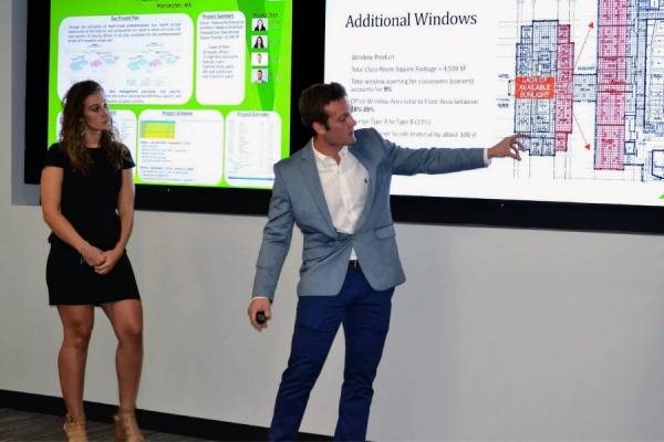 two students presenting in front of a classroom