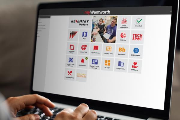 A closeup of hands on a laptop featuring the myWentworth website.