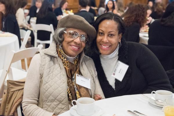 Two women smiling at a table during the Women@Wentworth breakfast