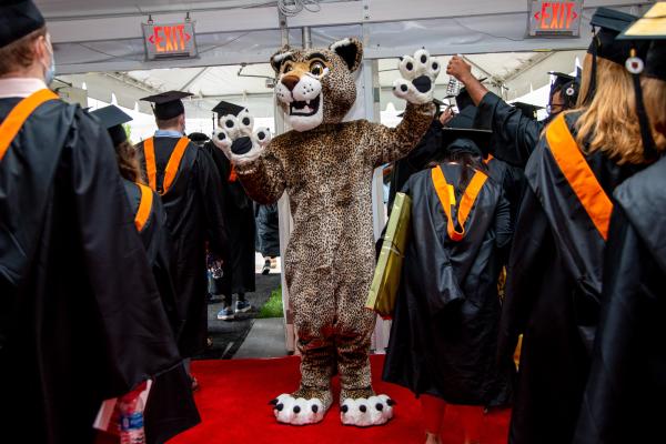 The Wentworth Leopard high fives graduates leaving tent. 
