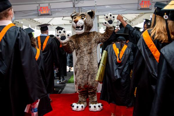 The Wentworth Leopard high fives graduates leaving tent.