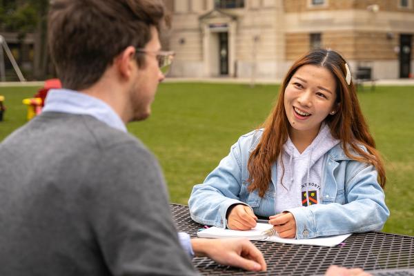 Student Fengnan Zhang speaks to another transfer student on the quad