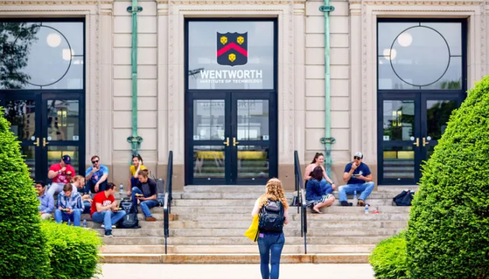 Students walk toward and gather on the front of Wentworth Hall 
