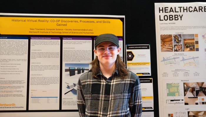 A student stands in front of their poster at the Academic Excellence Showcase