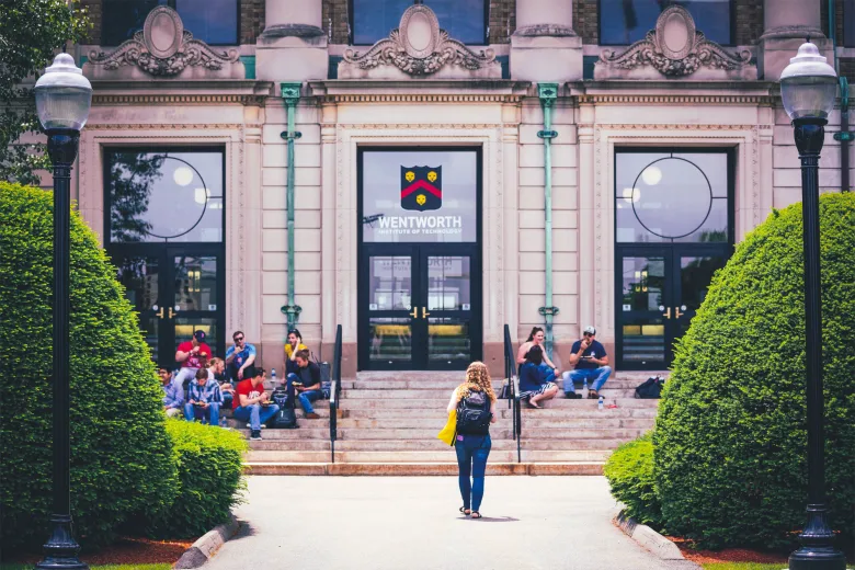 A student walks towards the front of Wentworth hall 