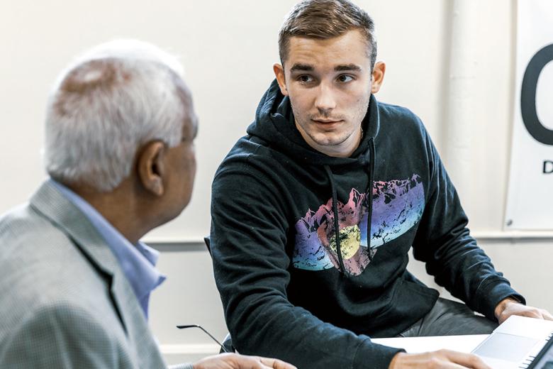 A male student talks to a professor