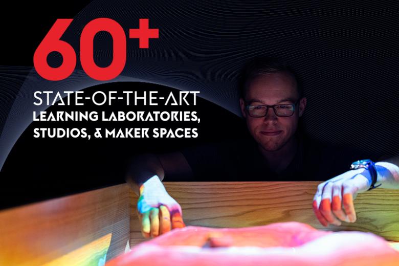 A man kneels in front of a colorful sandbox