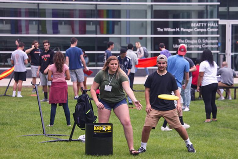 A group of students play frisbee on the Quad. 