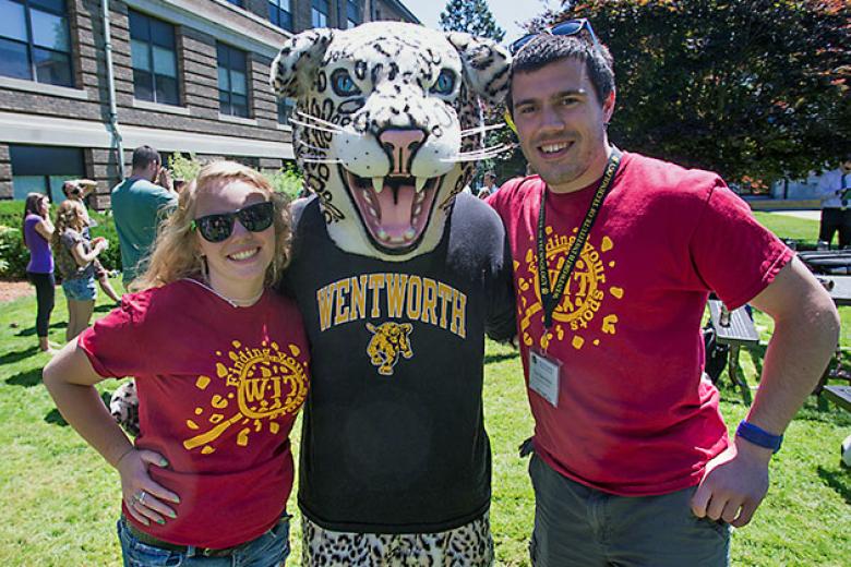 A female and male student pose on the Quad with the leopard mascot. 