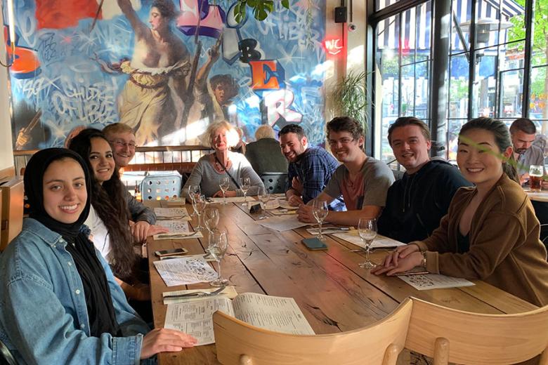 Group of students and faculty on study abroad trip sitting at table