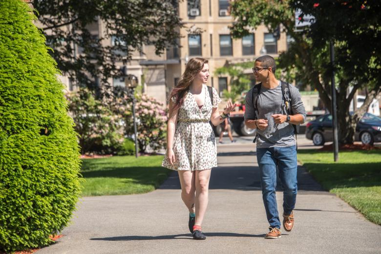 A man and woman walking and talking to each other.