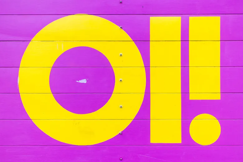 The words OI! in yellow written on a fuchsia wall