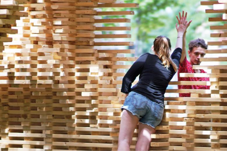 Students high-five while building pavilion.