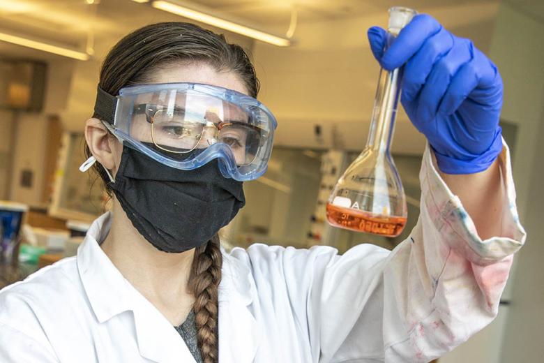 Student holding a beaker full of liquid