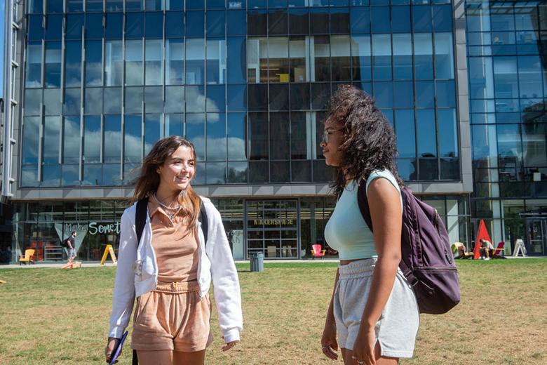 Two students in front of a building