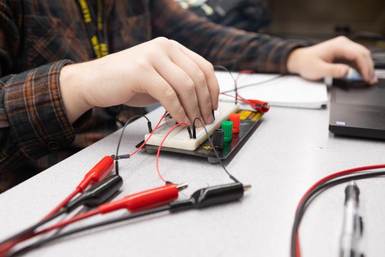 A students tests a circuit board in the lab
