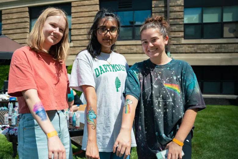 three women display temporary tattoos on arms