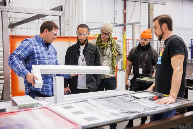 workers designing standing around a table