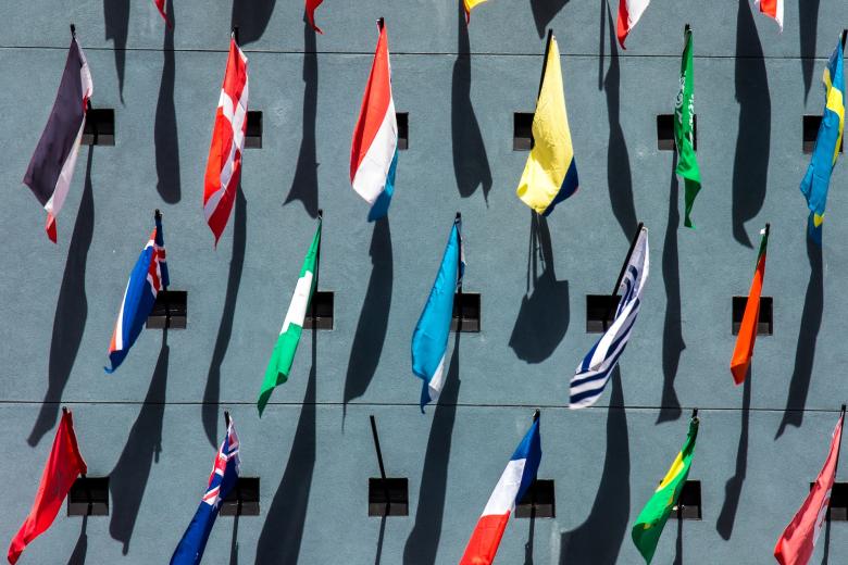Flags of countries around the world hanging together from a building