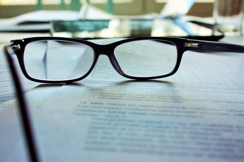 Eye glasses sitting on top of paperwork