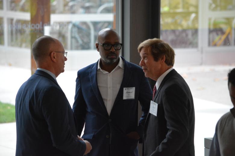 three men talking to each other