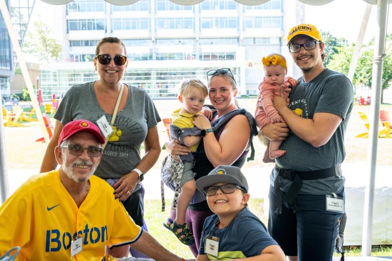 A group of alumni gather with their children before going to a Red Sox game together