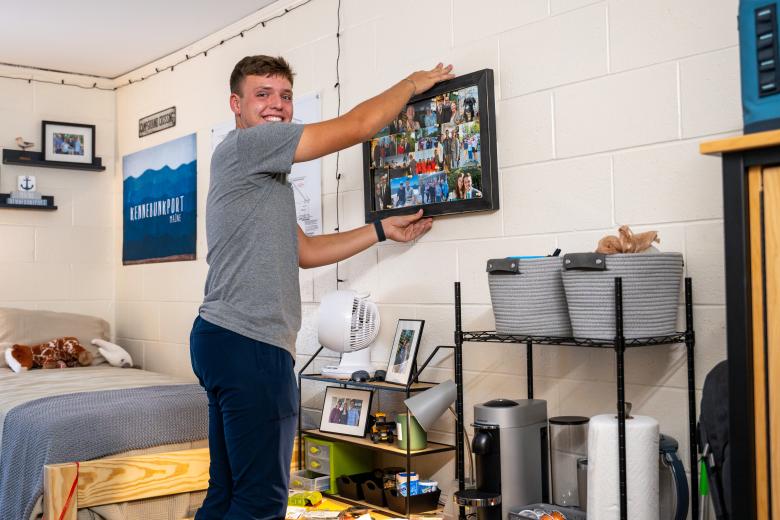 a man hangs up a poster on a wall