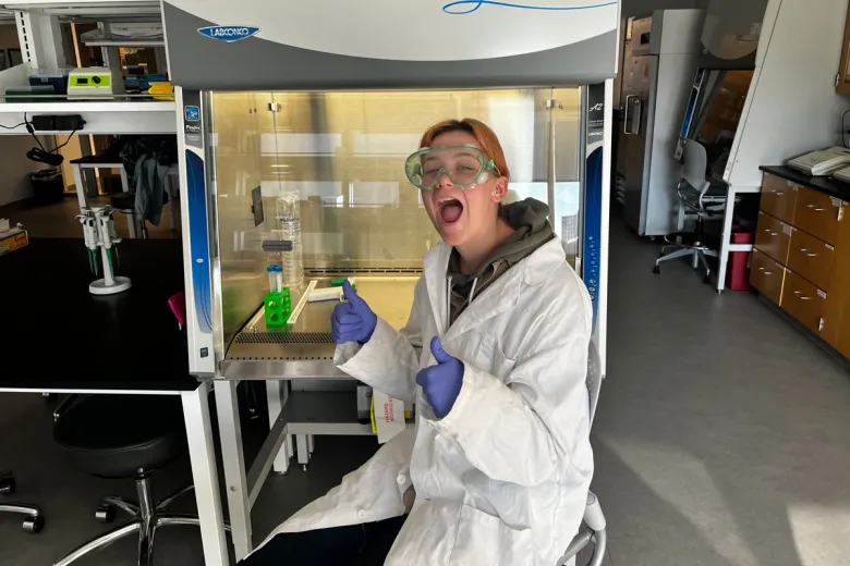 Jessica Rowe smiles in the lab while working on an experiment