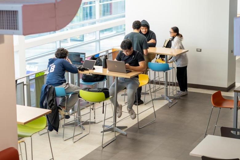 Students sit at tall tables in Beatty Hall and study or socialize