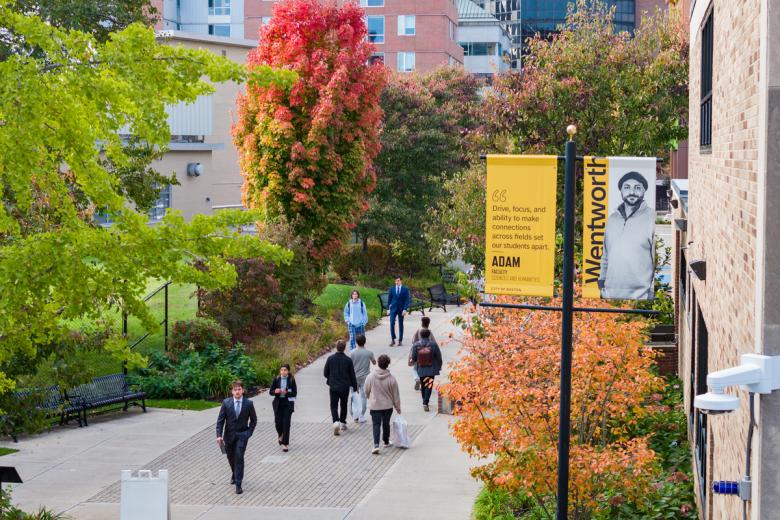 Students walking on the sidewalk that extends from the dorms to campus