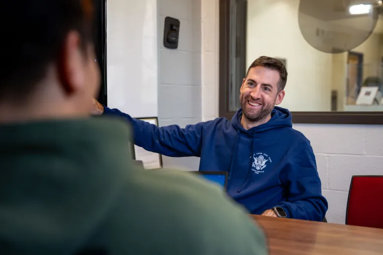 Two male students who are members of the military talk in the Military Connect Services space on campus