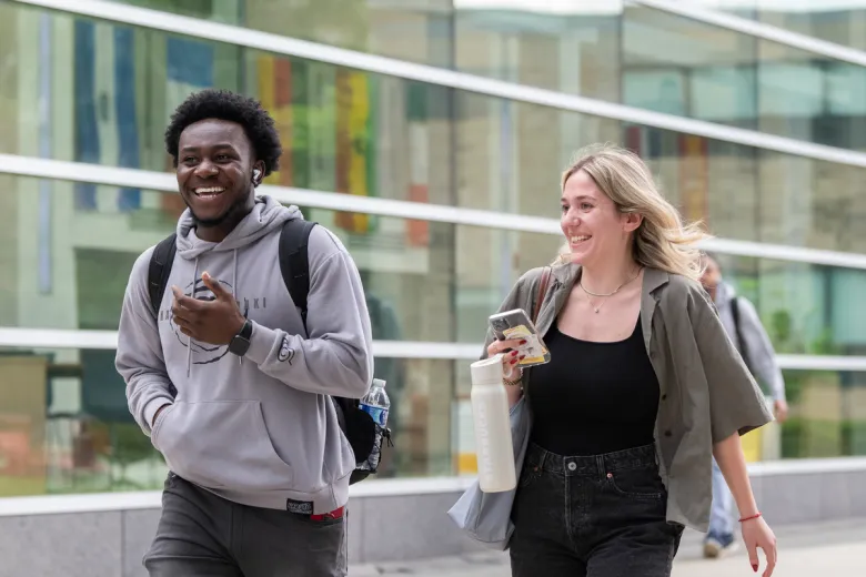 A man and woman walk next to Beatty hall on a spring afternoon.