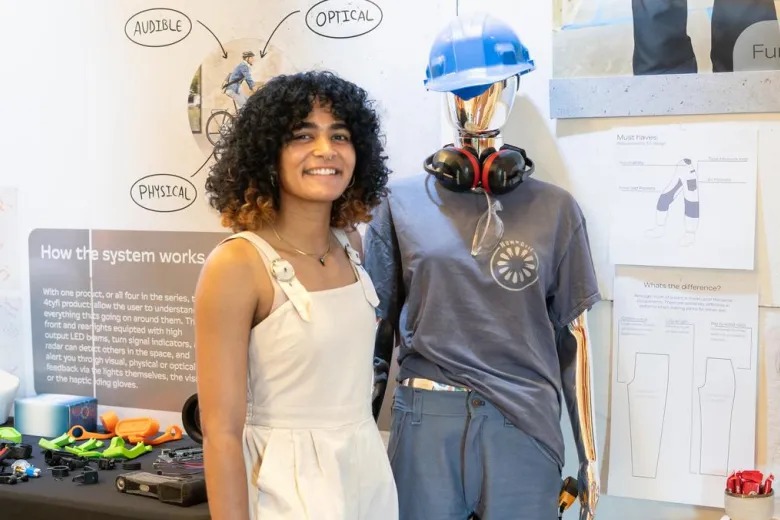 Zoe Graham stands in front of her workwear designed for female bodies called "New Grit"