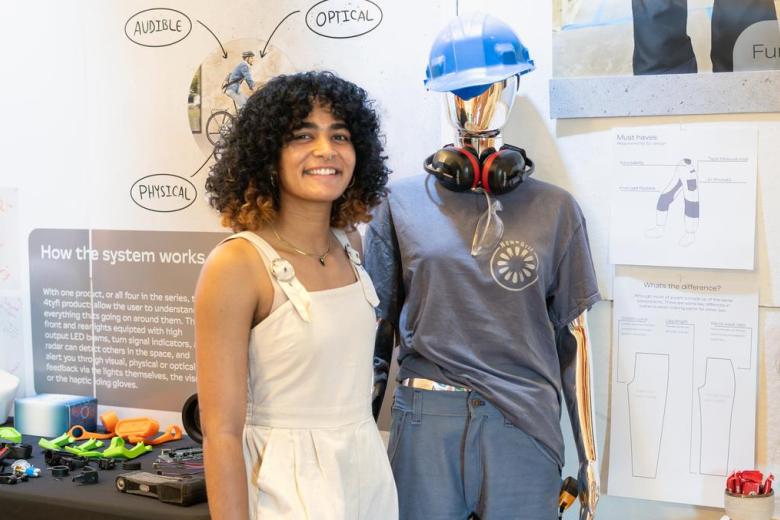 Zoe Graham stands in front of her workwear designed for female bodies called "New Grit"