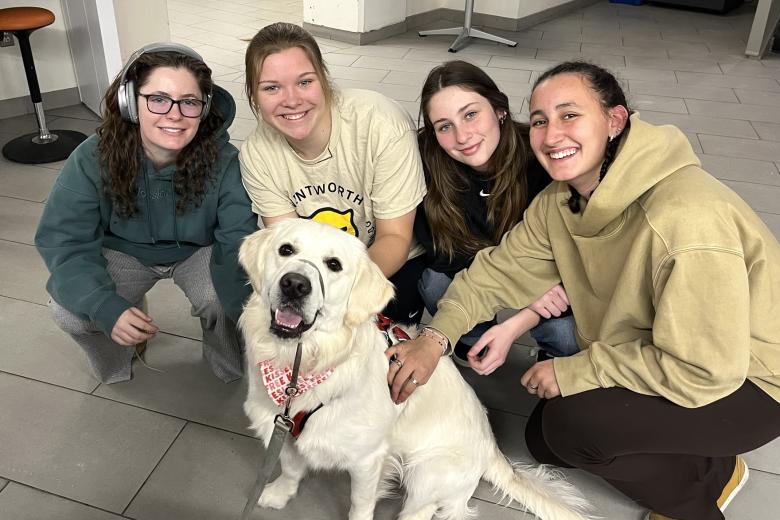 a group of students posing with a therapy dog