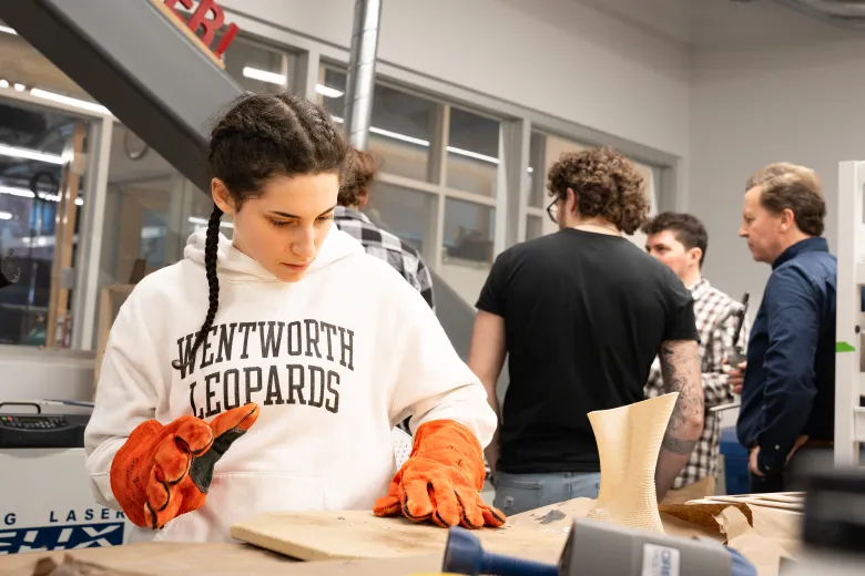 a woman loads a fabricated award into a machine