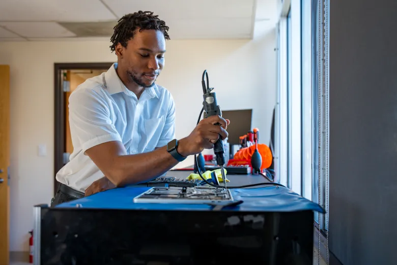 A student worker repairs a laptop at Tech Spot