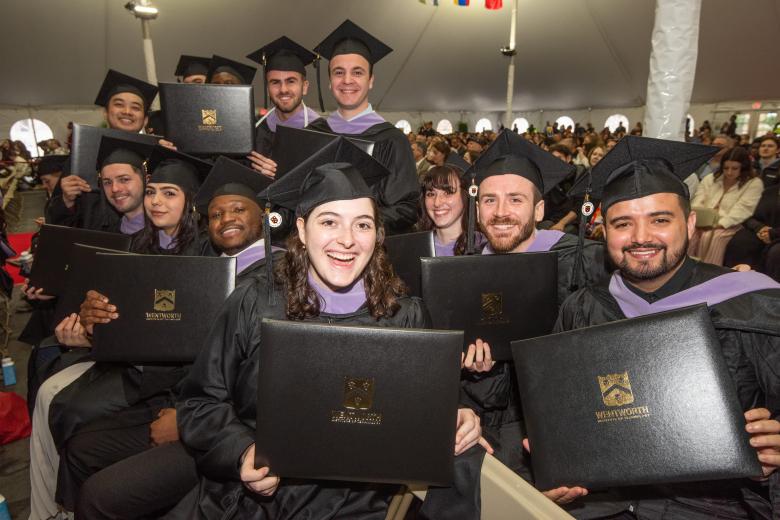 Students at Commencement, holding up degrees
