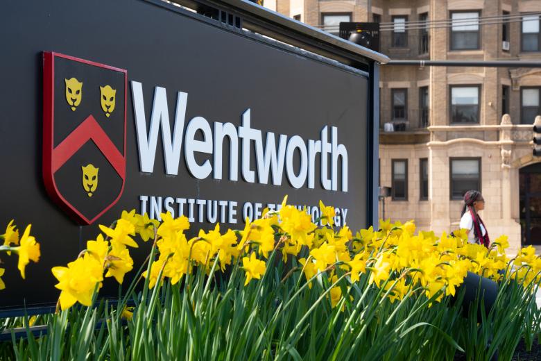 The Wentworth Institute of Technology sign on-campus surrounded by daffodils