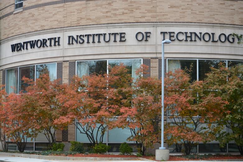 a sign reading "wentworth" on a building near autumn trees