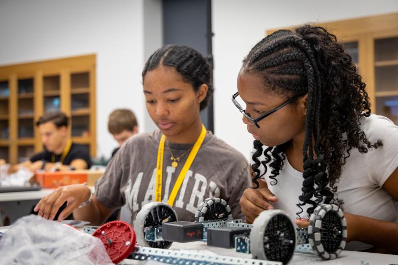 Two female students working on a robotics kit