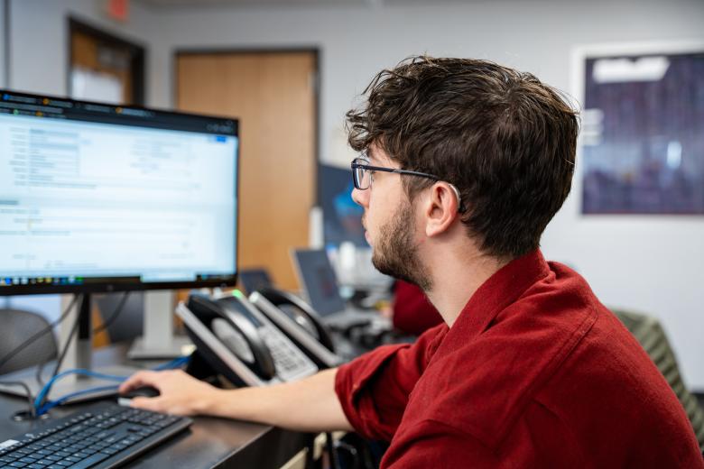 A person looking to the left while working on a computer.