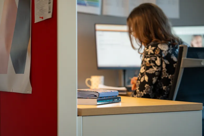 Staff member works independently on her laptop